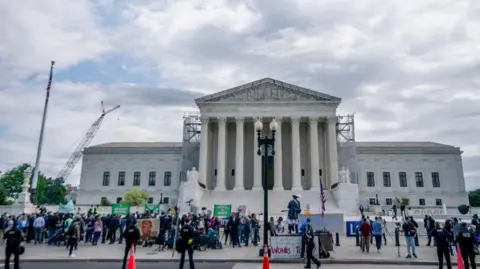 People stand in front of the US Supreme Court building