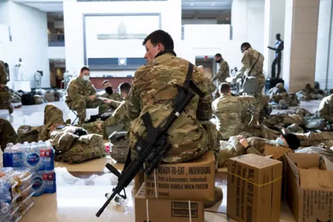 EPA Soldiers sit inside of visitors area, sitting on supplies including water bottles