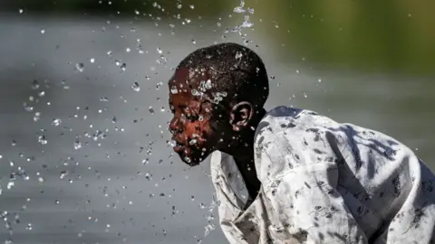 Getty Images A boy splashes himself with water in the Atbarah river near the village of Dukouli within the Quraysha locality, located in the Fashaqa al-Sughra agricultural region of Sudan's eastern Gedaref state on March 16, 2021. - The decades-old border dispute over the Fashaqa fertile farmland region, sandwiched between the Atbarah and Setit (or Tekeze) rivers, and where Ethiopia's northern Amhara and Tigray regions meet Sudan's eastern Gedaref state, dates back decades, feeding regional rivalry and even sparking fears of broader conflict. With the zone contested, the exact area is not clear, but Fashaqa covers some 12,000 square kilometres (4,630 square miles), an area claimed by both Sudan and Ethiopia.