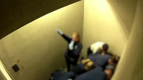 VRT  A still of video footage from Jozef Chovanec's cell, showing a police officer giving a Nazi salute
