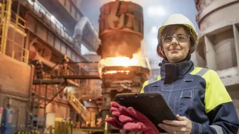 Getty Images Portrait of female steelworker during steel pour in steelworks
