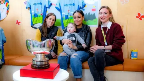 The Jockey Club Frankie with his mum alongside Rachael Blackmore and Jennifer Graham from Alder Hey