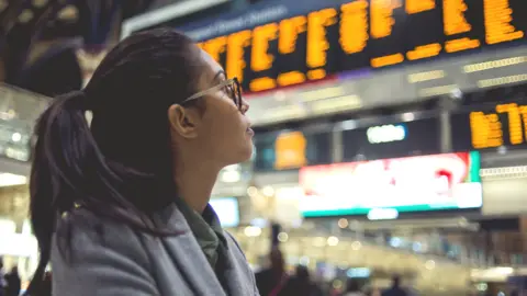 Getty Images Rail passenger looks at departure board