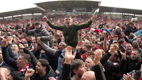 PA Media Fans invade the pitch after Wrexham earn promotion