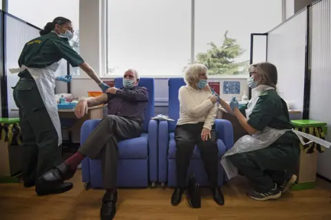 PA Media Victor (left) and Penny Griffiths getting their vaccine jabs this week at Basildon University Hospital in Essex