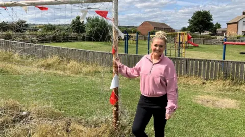 Beth Watson standing on the pitch in Hinderwell