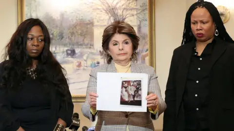 Getty Images Rochelle Washington (l), lawyer Gloria Allred and Latresa Scaff display photos taken on the night of the alleged abuse by R Kelly at Lotte New York Palace on February 21, 2019