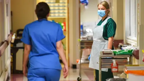 Medical staff (one seen wearing protective face mask) on the Covid-19 ward at the Neath Port Talbot Hospital, in Wales