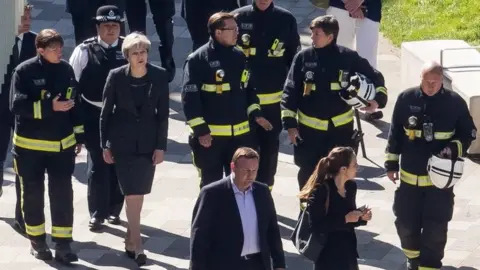 Getty Images Prime Minister Theresa May with firefighters