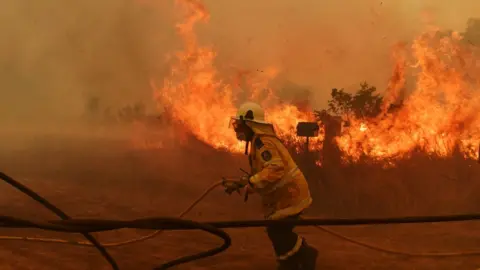 EPA A firefighter battles a blaze at Hillside in New South Wales on 13 November