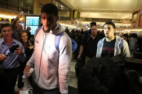 Reuters The players were mobbed by reporters upon their return to LAX airport