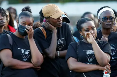 MONICAH MWANGI/REUTERS Women at a "Dark Valentine" vigil.