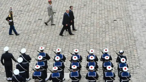 AFP/Getty Images  US President Donald Trump and French President Emmanuel Macron review troops during a welcome ceremony at Les Invalides in Paris, France, 13 July 2017