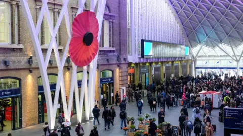 Future Publishing/Getty A giant red poppy hangs in the atrium on the concourse at King's Cross station