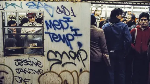 Getty Images People on a New York Metro train in the early 1980s