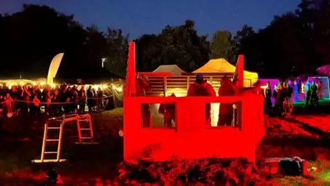 BBC A crowd watches as the wooden house is built on the Pontypridd Common