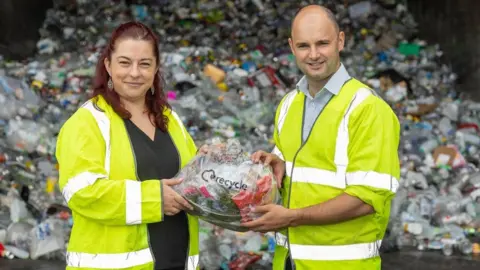 South Gloucestershire Council A man and woman wearing high visibility jackets holding plastic waste