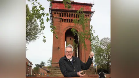 North Essex Heritage Griff Rhys Jones standing in front of the Jumbo Tower in Colchester