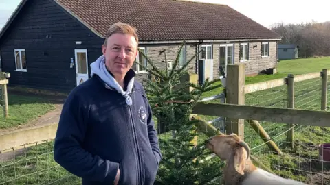 Luke Deal/BBC Nathan Nobbs with a goat and a donated tree