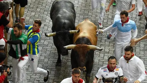 AFP Los participantes corren junto a los toros durante el encierro final del festival de San Fermín en Pamplona, ​​​​norte de España, el 14 de julio de 2018.