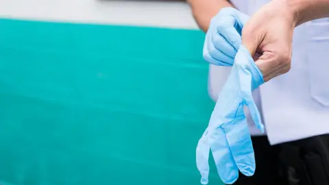 Care worker putting on gloves