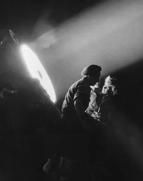Getty Images People are caught in the beam of a floodlight