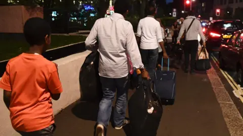 AFP/Getty Images Family walking with their bags out of Taplow tower
