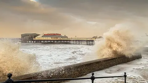 Waves crash over sea wall at Cromer in Norfolk