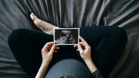 Getty Images pregnant woman looking at scan photo