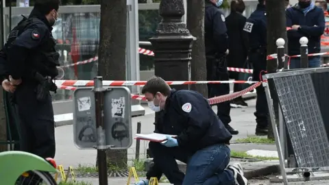 Getty Images Police investigate the scene of a shooting outside a Paris hospital, 12 April 2021