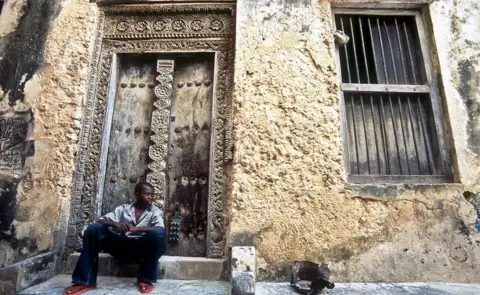 Getty Images A boy sits in front of a house in Lamu town.