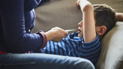 Getty Images A child and a thermometer