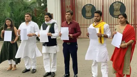 Getty Images Congress party leaders in Bihar holding up letters demanding a CBI probe