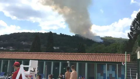 BBC Fire in the hills above an outdoor swimming pool