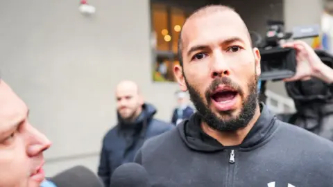 AFP Influencer Andrew Tate surrounded by press