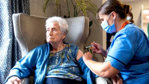 PA Media Woman gets Covid booster jab