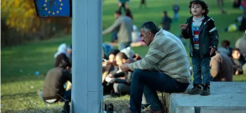 Getty Images Migrants take a rest after arriving with buses at the border to Austria on October 28, 2015 near Wegscheid, Germany