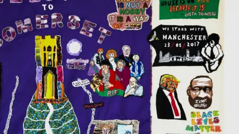 Joseph Horton A close up on a colourful tapestry including a golden Glastonbury Tor tower and the words solidarity with Manchester and the date of the Manchester Arena bombing