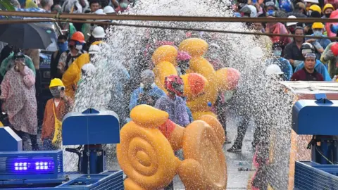 Getty Images Demonstrators use inflatable rubber ducks as shields to protect themselves from water cannons during an anti-government protest in Bangkok, Thailand, 17 November 2020