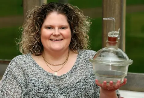 PA Louise Brown, the world's first test tube baby, holds the incubator jar in which her embryo was incubated