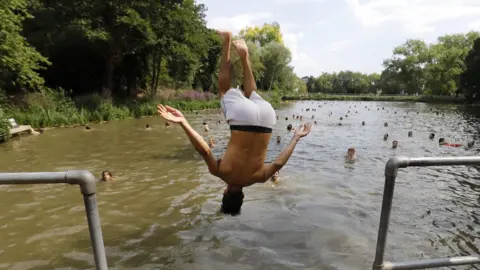 AFP A bather jumps into the pond on Hampstead Heath, London