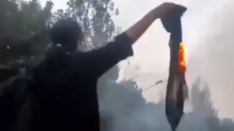 Twitter A video posted on social media shows Nika Shakarami burning a headscarf at a protest in Tehran, Iran, on 20 September 2022