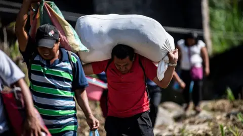 AFP People walk after having crossed illegally the Suchiate river from El Carmen in Guatemala to Talisman in Chiapas State, Mexico, on June 7, 2019