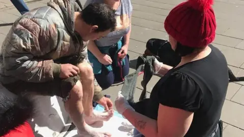 Homeless Hope A homeless man has his feet examined by volunteers for Homeless Help