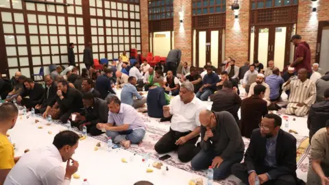 Getty Images People sharing food at the Al Manaar Mosque in 2017