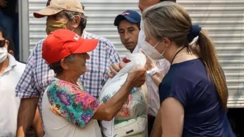 EPA Relatives of former Paraguayan vice president Oscar Denis deliver food in Concepcion, Paraguay, 13 September 2020.