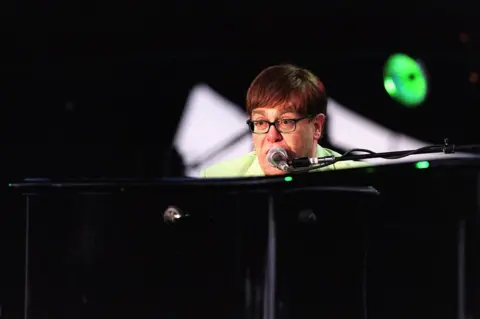Pacemaker Elton John playing the piano and signing during his concert at Stormont
