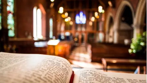 Getty Images An open Bible looking out into a church.
