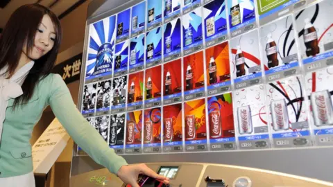 Getty Images Model demonstrates Coca-Cola Japan Company's (CCJC) new 'e-40' vending machine in 2008