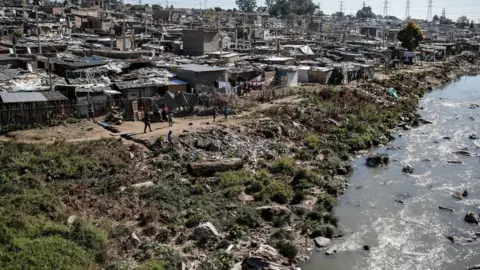 Getty Images Plastic and other waste litter the Jukskei River which runs through Alexandra Township in Johannesburg on 3 June 2018